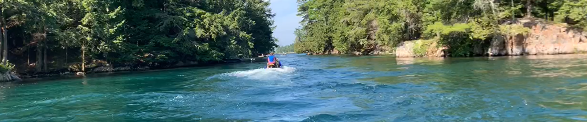 Jet ski in the 1000 Islands on the River passing between two islands